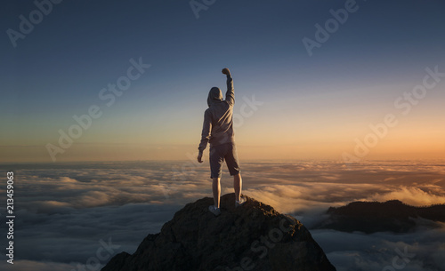 Na szczycie świata. Człowiek na szczycie góry ponad chmurami.