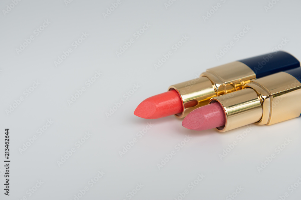 Minimal concept of creative female cosmetic for pink and red lipstick on the white background with copy space Minimal concept of creative female cosmetic for pink and red lipstick on the white background with copy space