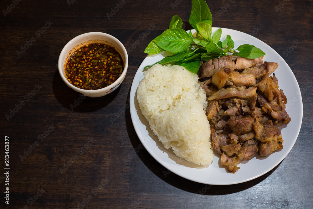 Special Thai Lao food (charcoal boiled pork neck and sticky rice) on wooden table. Special Thai Lao food (charcoal boiled pork neck and sticky rice) on wooden table.