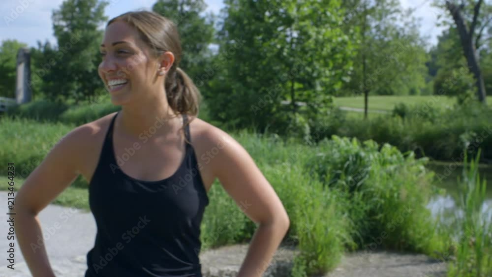 a female runner smiles and exhales on the running path after a long run in Forest Park a female runner smiles and exhales on the running path after a long run in Forest Park