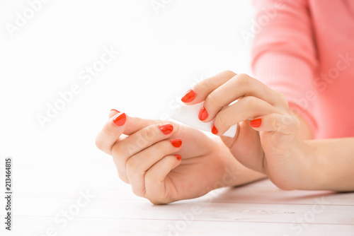 Female hands with manicure and red lacquer on a white table in the beauty salon. closeup of hand of a young woman