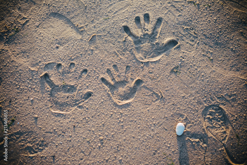 The family left hand prints on the sand on the beach