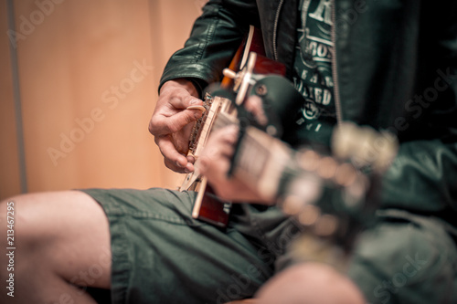 Junger Mann spielt Gitarre mit Plektrum © Cedrik