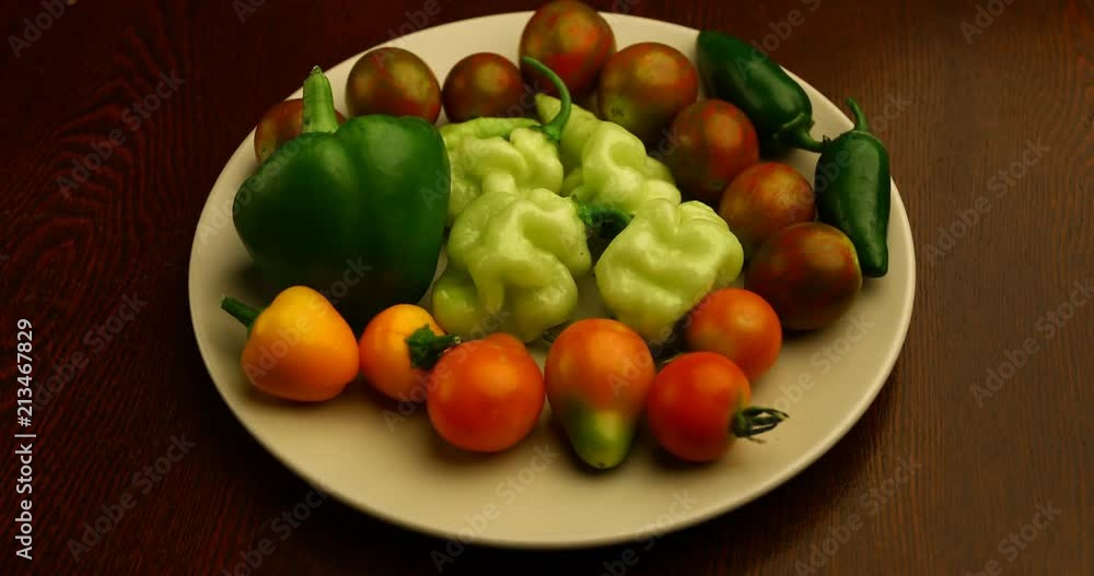 Plate with home grown vegetables. Tomatoes, pimento pepper, habanada peppers and jalapenos. Plate with home grown vegetables. Tomatoes, pimento pepper, habanada peppers and jalapenos.