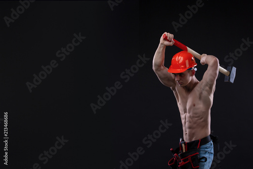 Handsome young topless construction worker with sledge hammer, studio shot, black background. builder © Volodymyr Shcerbak
