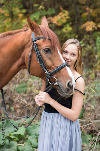 a young, blonde girl posing with a horse, a beautiful girl and a strong horse.
