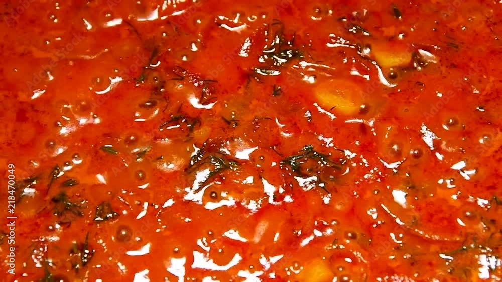 Tomato sauce with vegetables boils and gurgles during cooking closeup Tomato sauce with vegetables boils and gurgles during cooking closeup