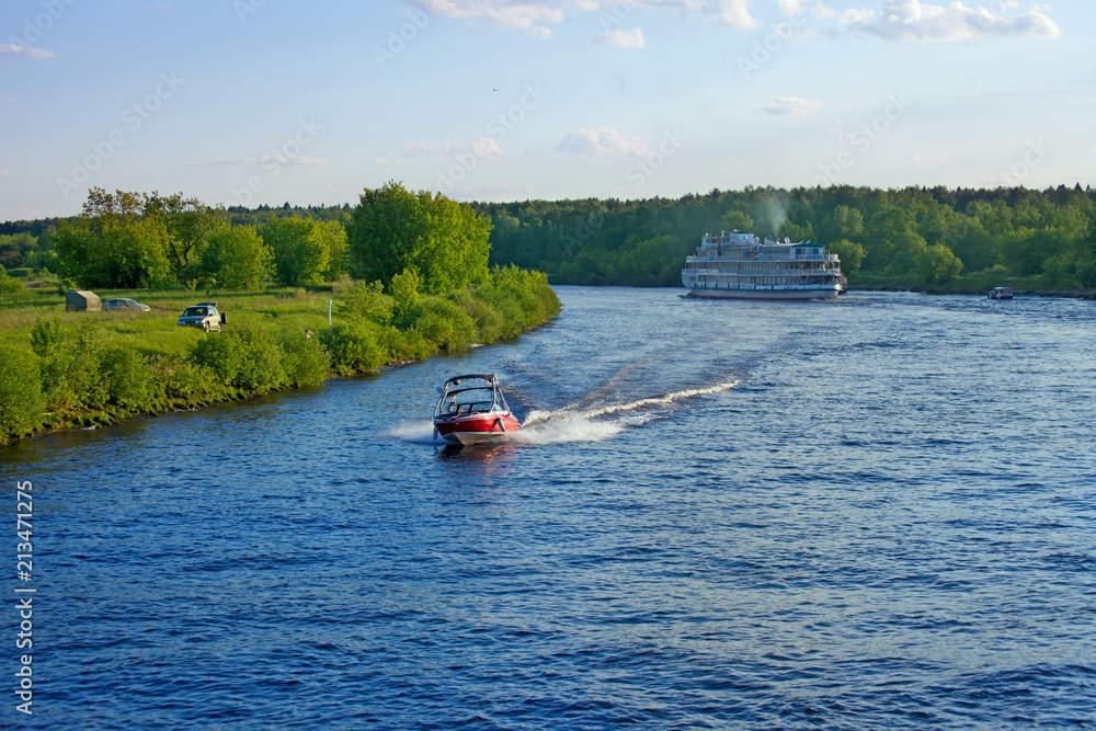 Fototapeta premium Landscape with Volga river, motor boat and cruise ship on a summer evening
