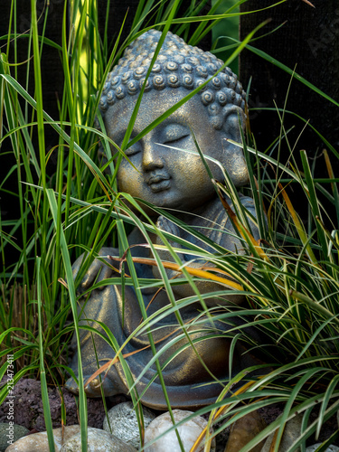 decoration buddha statue little in a garden outdoor covered with grass