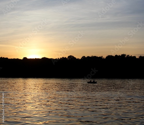 The sun going down under the hill at the lake.