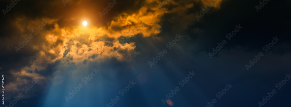 blurred background, sun and rays on a dark background of thunderclouds.