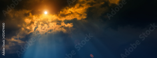 blurred background  sun and rays on a dark background of thunderclouds.