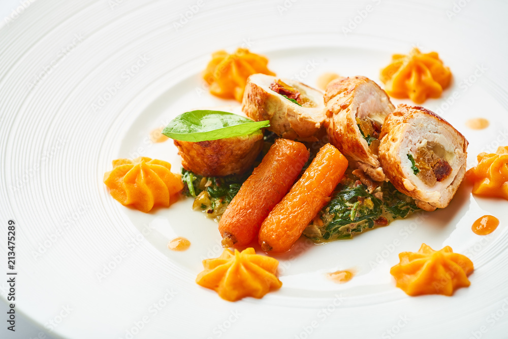 Poultry rolls with carrot puree, orange on a white plate Poultry rolls with carrot puree, orange on a white plate