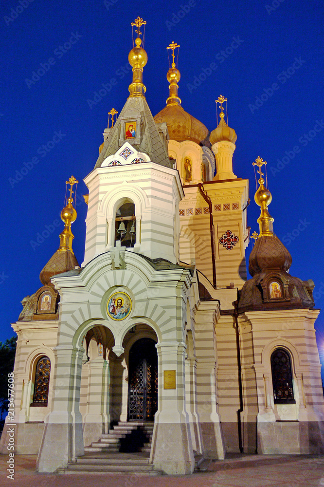 Church with icons and golden domes with crosses against the background of a dark, blue evening sky