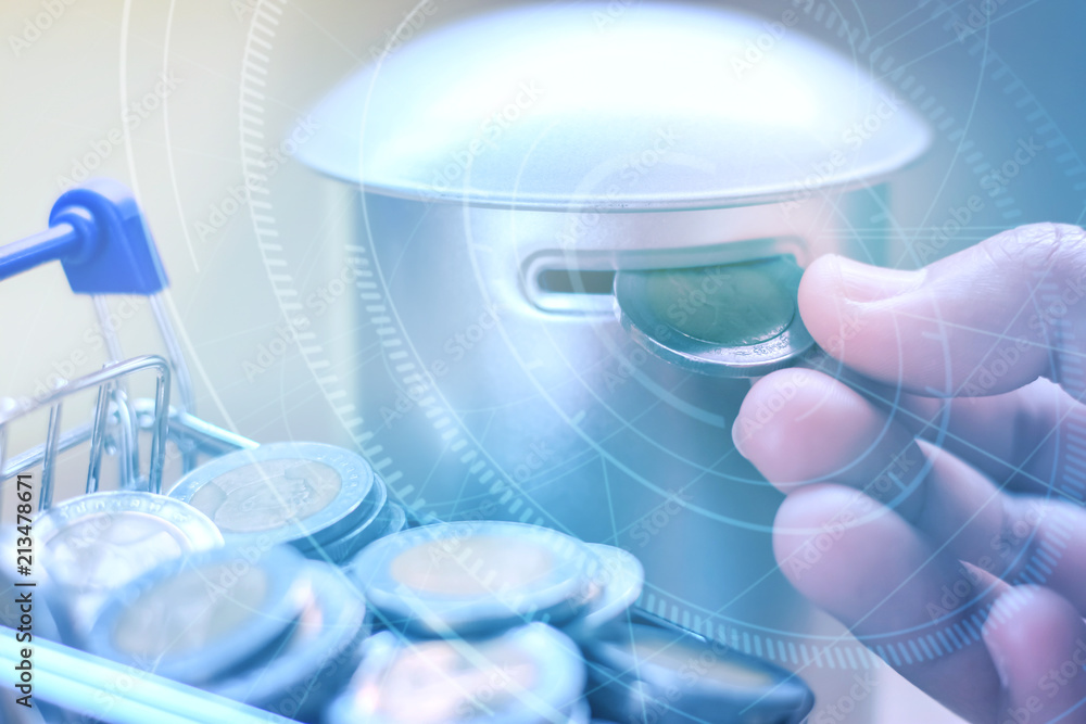 Hand picking coins from a Shopping cart into a coin bank with digital graphic, Saving money concept. Hand picking coins from a Shopping cart into a coin bank with digital graphic, Saving money concept.