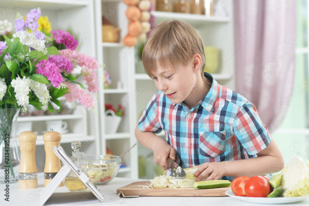 Cute little boy making dinner