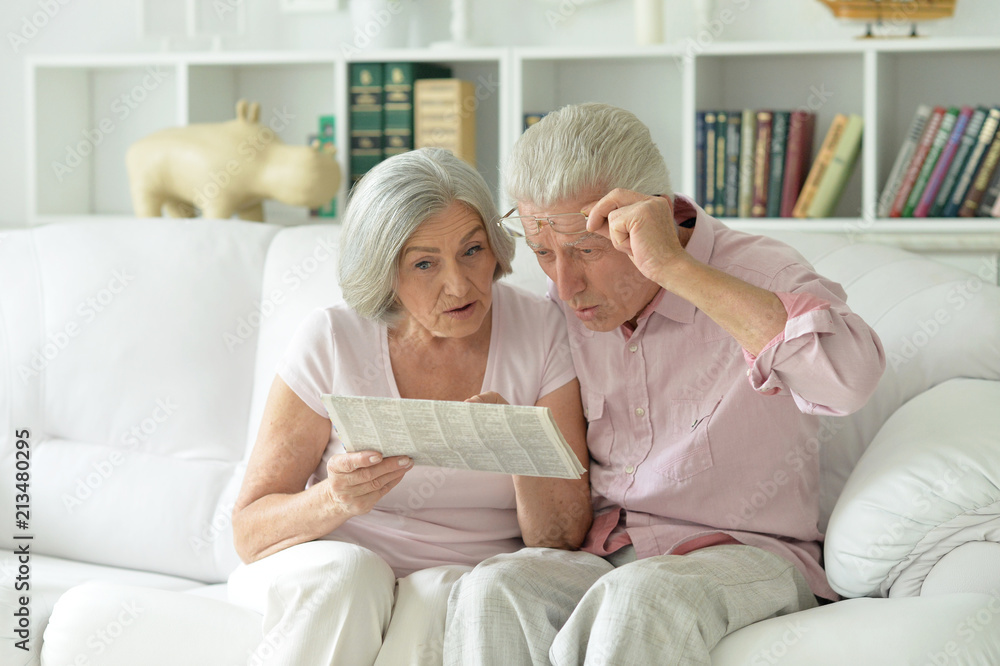 Close-up portrait of a senior couple with newspaper Close-up portrait of a senior couple with newspaper
