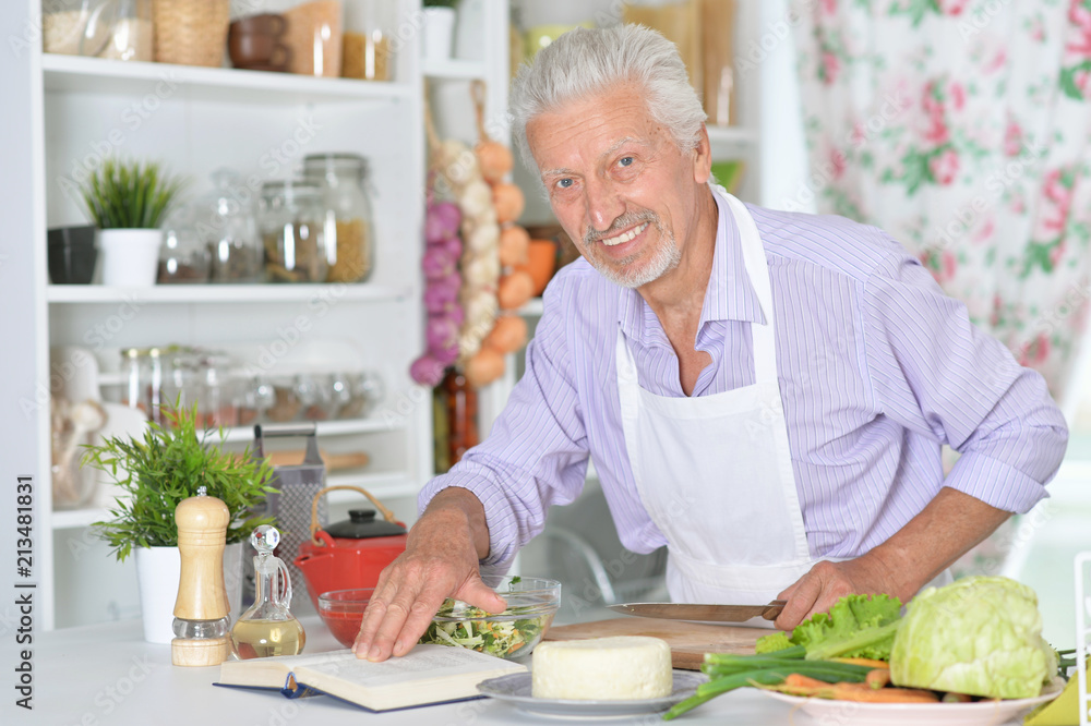 Senior man preparing dinner in kitchen Senior man preparing dinner in kitchen