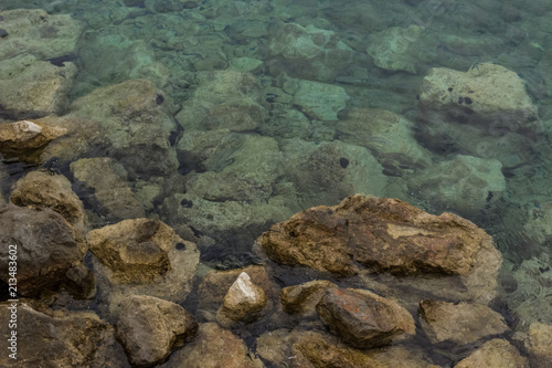 sea waterfront surface and stones near and under water nature concept with empty space for copy or text