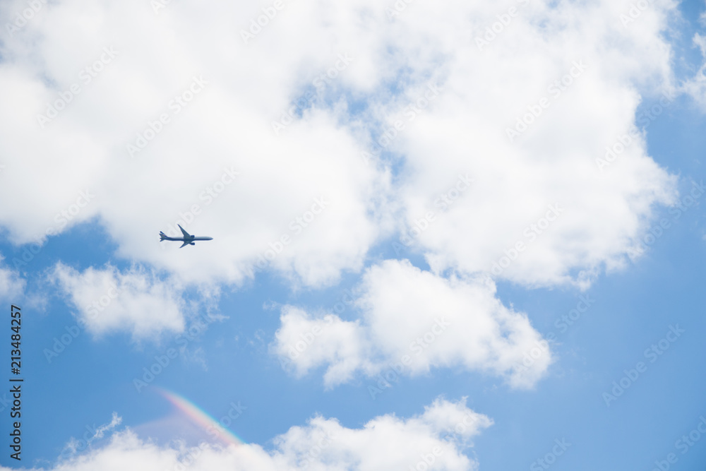 Image of flying airplane in clear sky with sun at background