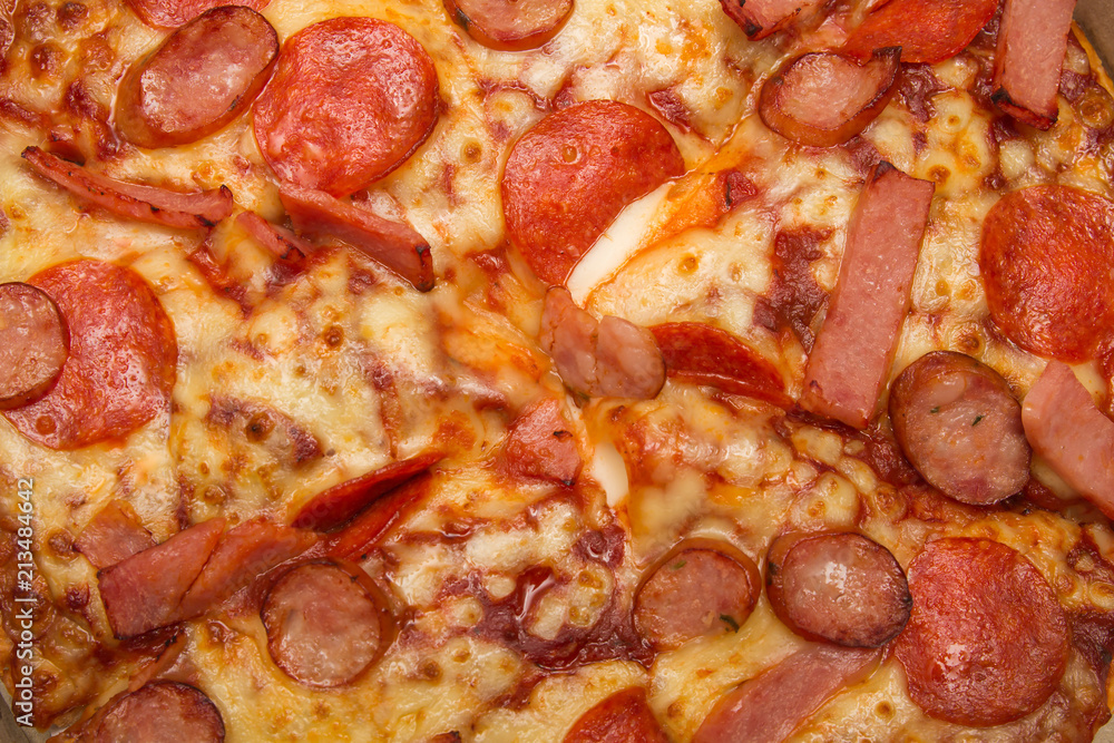 Background of close-up pizza with topping of hams, sausages and cheese Background of close-up pizza with topping of hams, sausages and cheese