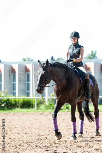 Teenage girl equestrian riding horseback at riding school place