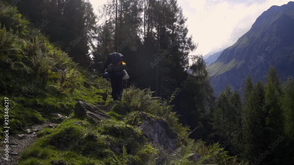 Two men are walking on a mountain terrain with a beautiful scenery. Two men are walking on a mountain terrain with a beautiful scenery.