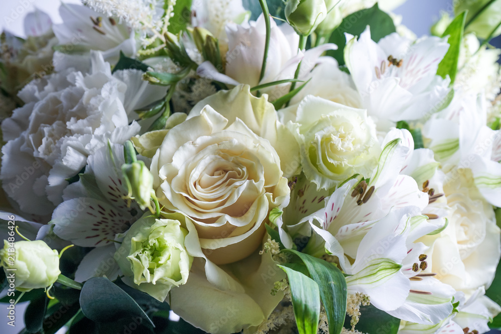 Obraz premium beautiful wedding bouquet with white roses and other flowers on wooden background with 2 wooden pigeons