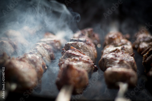 Barbecue outdoors on the grill.cooking meat on the street. street diner. picnic. family holiday. the meat on the shampoo. The heat from the grilled meat. the heat from the coals on the grill