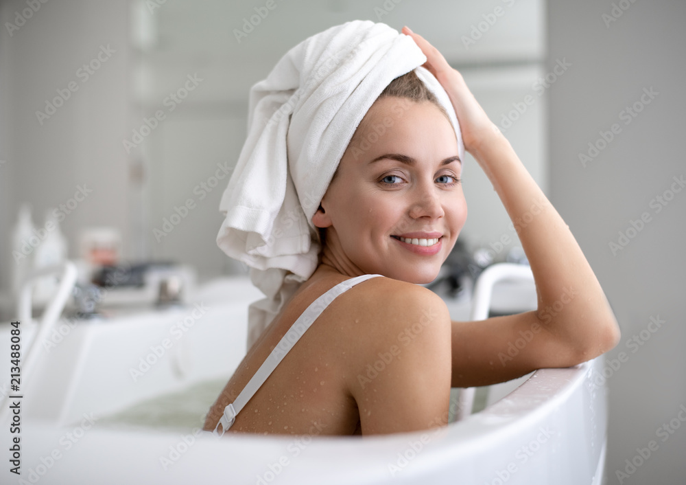 Portrait of satisfied girl locating in water during treatment in spa center Portrait of satisfied girl locating in water during treatment in spa center