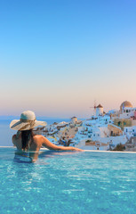 Woman enjoying relaxation in pool and looking at the view
