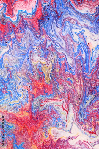 Swirling, mixing paints of blue, white and red 