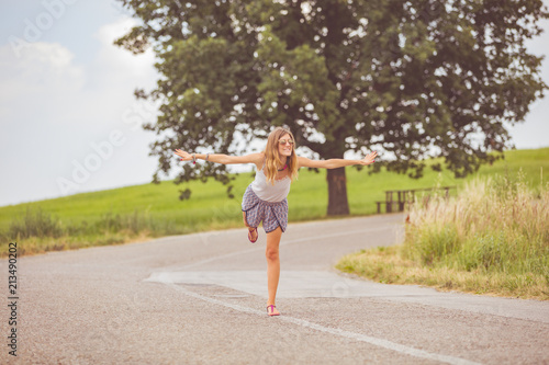 Girl enjoying on a empty suburb road. © astrosystem