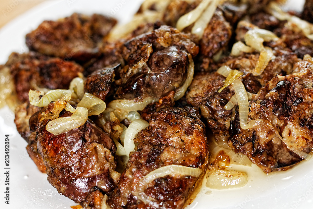 Fried chicken's livers on white plate on a wooden table Fried chicken's livers on white plate on a wooden table