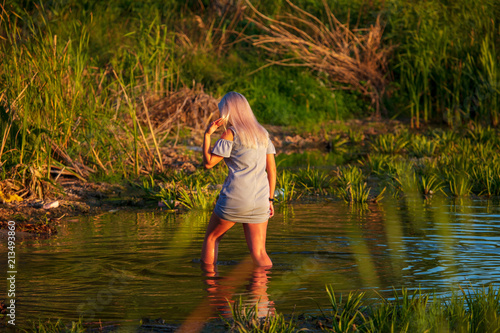 Girl in the water lake at sunset