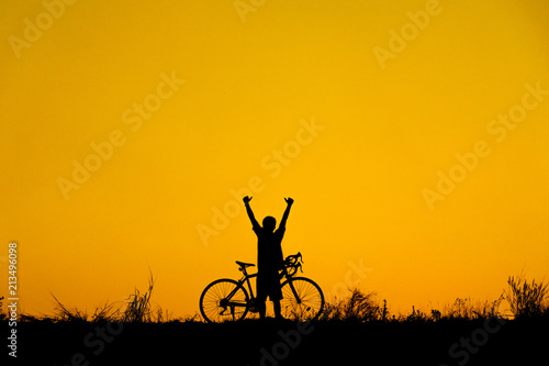 Silhouette of cyclist with friend in motion on the background of beautiful sunset