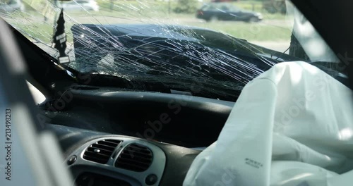 Details of a damages in a car crashed against the tree on the city street photo