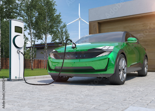 Green Electric car charging its batteries at Home with clean Energy from a Wind Turbine in the background