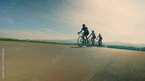 Close up, low angle, tracking shot of cyclists on countryside road photo