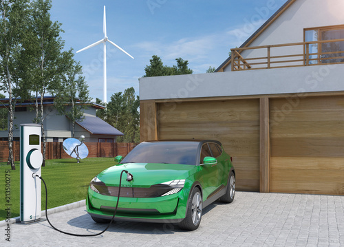Elektroauto SUV in grün tankt Strom zu Hause mit Windrad im Hintergrund