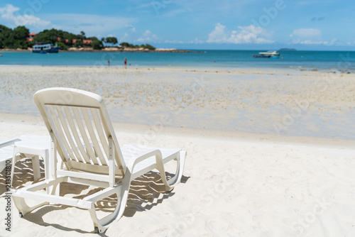 empty beach chair over looking the clear blue sky and ocean