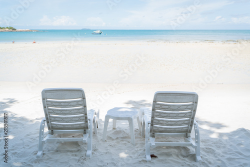 empty beach chair over looking the clear blue sky and ocean