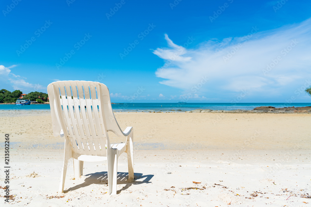 empty beach chair over looking the clear blue sky and ocean