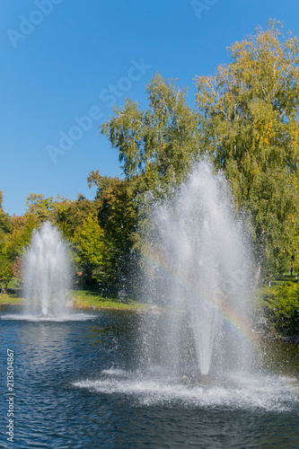 Two large hitting fountains in the middle of a clear blue decorative lake