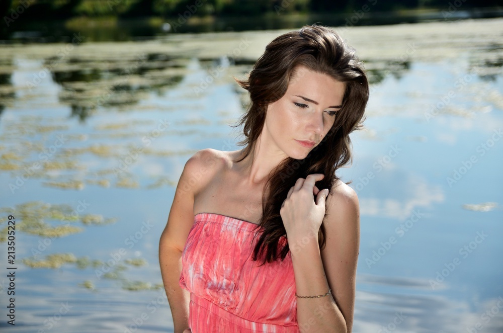 Young woman in red dress at lake