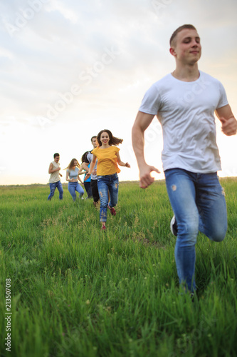 Group of people running in the grass, © Evgenia Tiplyashina