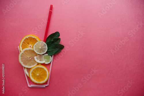 Conceptual photography. Citrus lemonade or juice from fresh fruits in a glass of tubules