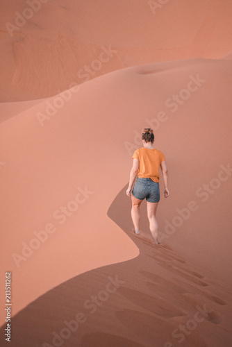 Girl walking in sand in Sahara