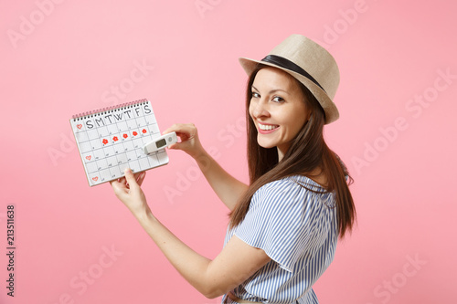 Back rear view woman in dress hold in hand thermometer, female periods calendar, checking menstruation days isolated on pink background. Medical healthcare, ovulation gynecological concept. Copy space photo