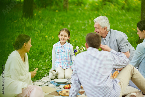 Happy little girl looking at her grandmother during talk at family picnic © pressmaster